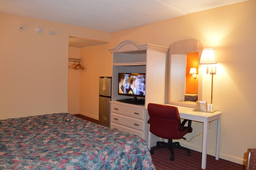 Travelers Inn standard room with a bed, refrigerator, television, and desk